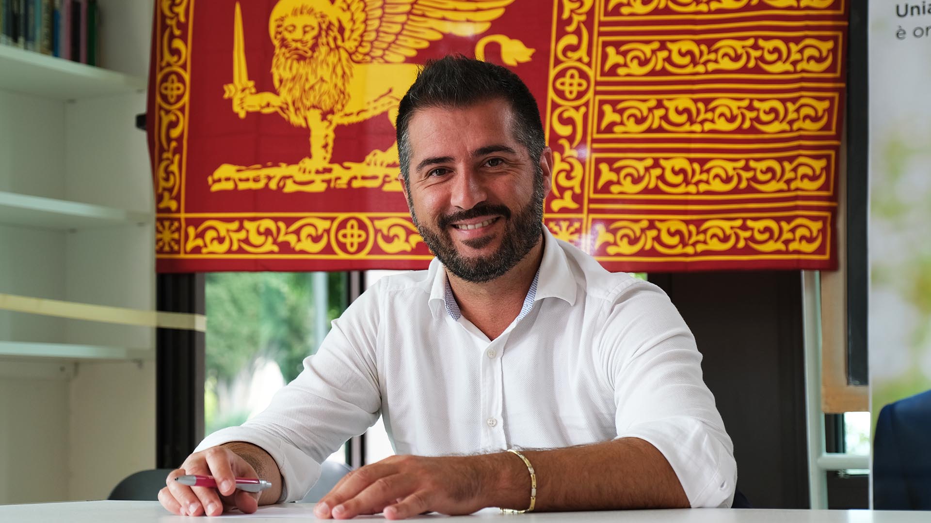 Paolo Borchia con sullo sfondo la baniera di San Marco